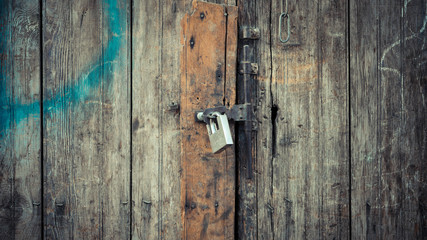 padlock locked on to wooden door with lines