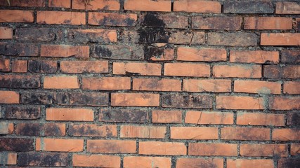 Red brick wall with black spot in the middle