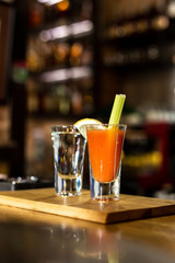 Cocktail in a glass with Tobasco and alcohol. Sambuca. A slice of lemon and celery. The interior of the bar.