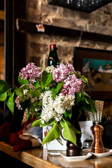 Fototapeta na wymiar Lilac in a vase bar counter