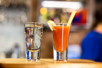 Cocktail in a glass with Tobasco and alcohol. Sambuca. A slice of lemon and celery. The interior of the bar.