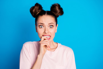 Close-up portrait of her she nice attractive lovely pretty worried terrified scared brown-haired girl biting finger phobia isolated on bright vivid shine vibrant blue color background