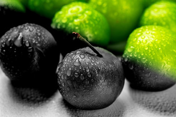 Close-up macro fresh green sour plum. Greengage on white background.  Colorful, black and white.  Creative concept.