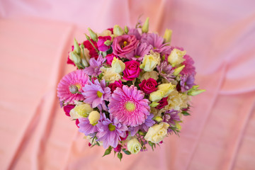 A joyful bouquet of fresh flowers in a pink paper box on a pink background (Colors: white, pink, lilac, red, green, fuchsia. Flowers: eustoma, rose, chrysanthemum, gerbera)