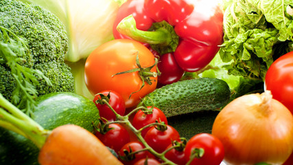 Beautiful background with sun shining on fresh ripe vegetables from garden lyign on table