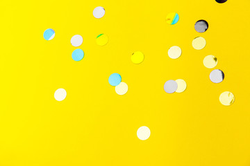 Fototapeta na wymiar colorful sprinkles over yellow background, decoration for holiday and party