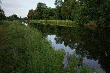 Obraz premium Water reflection of Havel river canal Voßkanal in Krewelin, Oberhavel, Ruppiner Lakeland, Brandenburg, Germany, section of famous Berlin-Copenhagen Cycle Route 