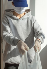 A young volunteer passes a bag of food in containers during a crown virus pandemic