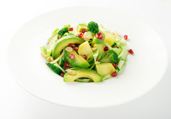 Green Salad with Avocado, Cucumber and Nuts on White Plate