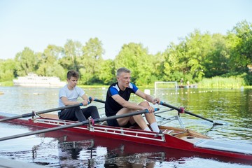 Team of two teenage boys kayaking on river