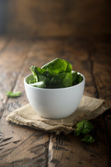 Fresh baby spinach in a white bowl