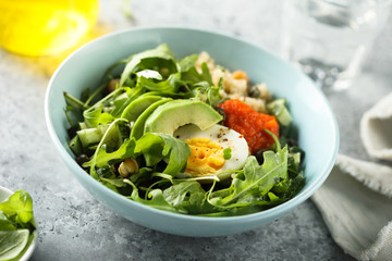 Healthy quinoa bowl with arugula, egg and avocado
