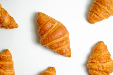Naklejka na ściany i meble Studio shot of appealing plain mini croissant baked to golden crisp isolated on white backgroud. Traditional french pastry. Close up, copy space, top view.