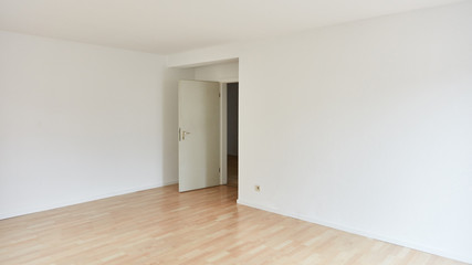 Großer leerer Raum mit Zimmertür nach Renovierung
