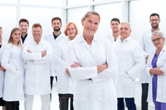 Large Group Of People In White Coats Standing Together.