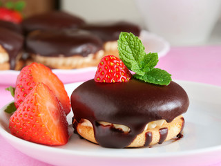 Chocolate covered sandwich cookies with vanilla cream and strawberries
