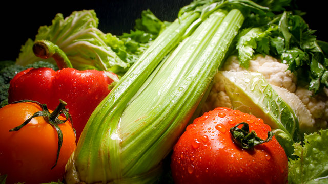 Closeup photo of water droplets falling on fresh ripe vegetables. Background for healthy food and GMO free products.Diet nutrition and fresh vegetables. Vegan and vegetarian background.