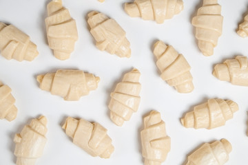 Close up studio shot of semi-finished frozen ready to cook croissant isolated on white background....