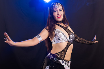 Belly dancer. Young attractive woman dancing tribal fusion on the stage. Oriental exotic dance.