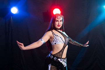 Girl dancing belly dance, fusion or tribal. A woman in a beautiful costume demonstrates charming...