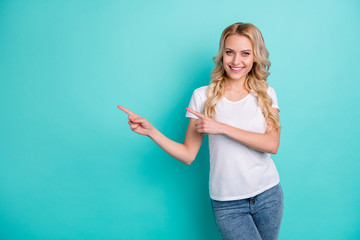Portrait of positive cheerful girl promoter point index finger copyspace demonstrate adverts promotion recommend suggest select wear good look clothes isolated over teal color background