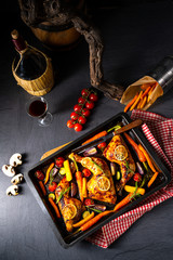 Grilled chicken legs with various vegetables and herbs.