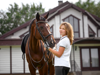 Fototapeta premium portrait of a pretty young girl with a browne horse