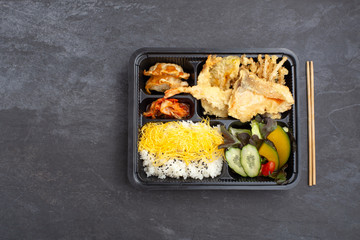 Japanese tempura bento on dark stone background