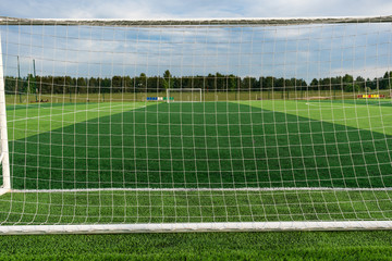 Football goal on the field, view of the goal from behind