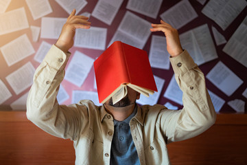 Man with a book falling on his head Concept of acquiring knowledge. Creativity and reading.