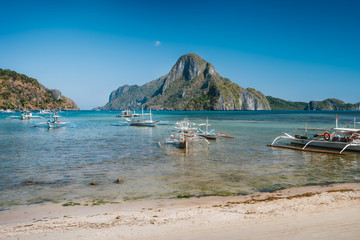 Fototapeta na wymiar El Nido bay with island hopping boats. Cadlao island in background, Palawan, Philippines