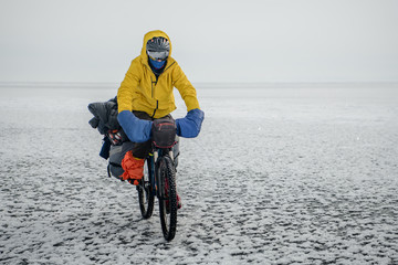 Bicyclist on Baikal lake in winter, Siberia, Russia