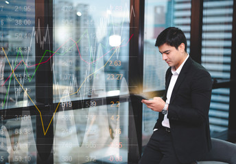 Young brokers using a smartphone in an abstract city with a double touch of blurry digital graphs. Stock market concepts, investments, and technology.