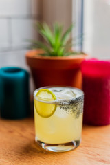 An iced sour cocktail in rocks glass with lemon wheel
