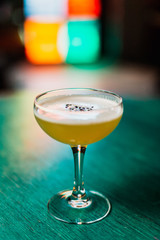 A classic sour cocktail in coupe glass with sesam seeds