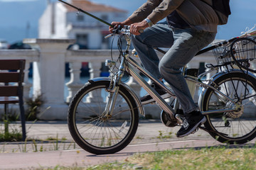 Naklejka premium man with fishing rod rides a bicycle