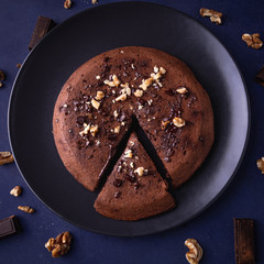 Homemade chocolate cake with nuts on a dark blue background