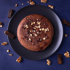 Homemade chocolate cake with nuts on a dark blue background