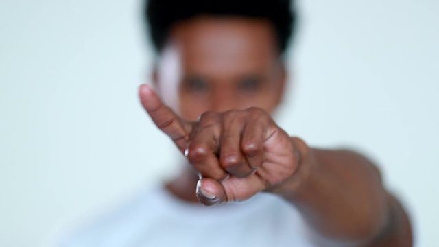 Person pointing finger to camera rejecting with finger, black african in confrontation denying, disapproval