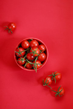 red cherry tomatoes on white marbel background on colorful red background