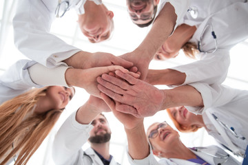 Fototapeta na wymiar close up. group of different doctors putting their hands together