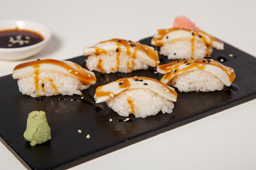 Isolated image of flambé butter fish nigiri dish on white background.