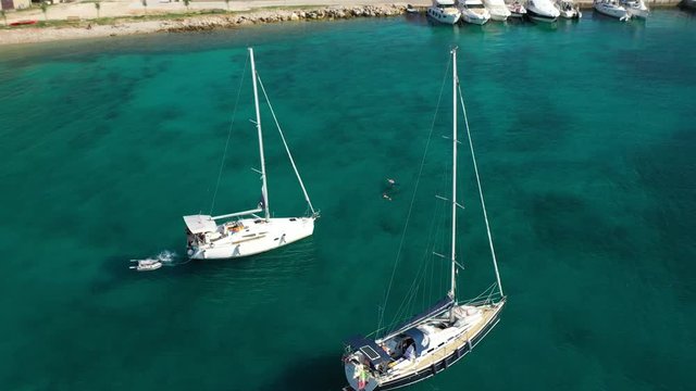 Beautiful white sailboats anchored by the beach of Olib Island in Croatia - aerial