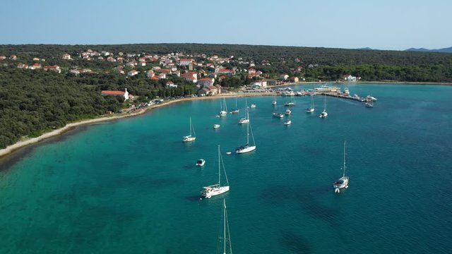 The Beautiful Island Of Olib In Croatia - Green Trees On The Sand Surrounded By Bright Blue Sea With Boats Adrift On A Summer Day - aerial shot