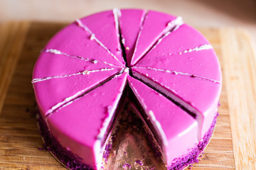Pink and violet birthday cake without one piece. Dessert, holidays and delicious concept.
