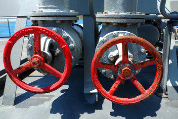 Pipes and valves with red knobs . Control knob for water pipes