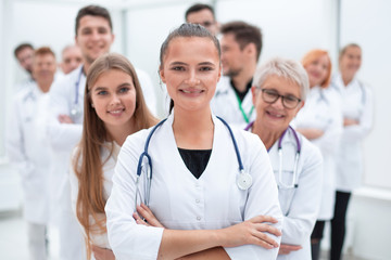 Obraz premium young female doctor standing in front of her older colleagues.
