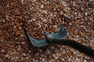 Black spade in gravel. Small stones