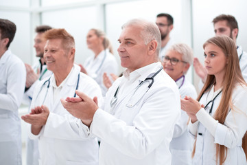 large group of medical practitioners applauding together.