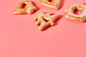 Various festive christmas cookie scattered on pink background. New year celebration concept